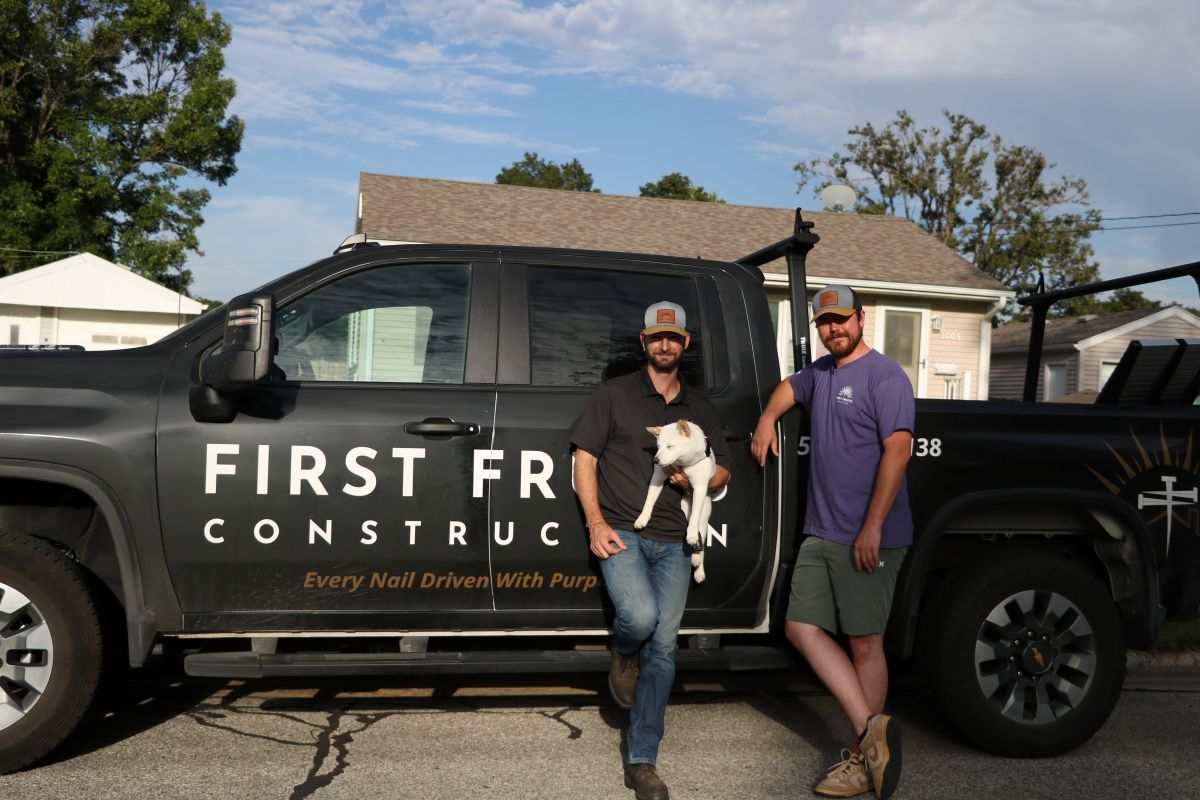First Fruits Construction team and dog in front of company car