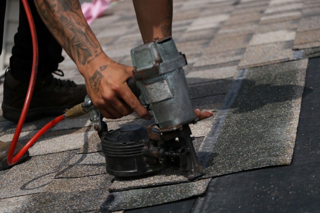 Roofer installing shingles